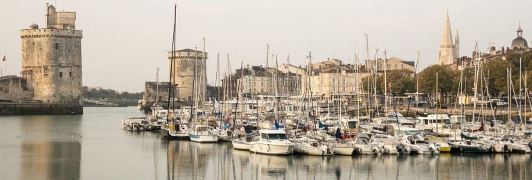 Port de La Rochelle avec bateaux et tours.