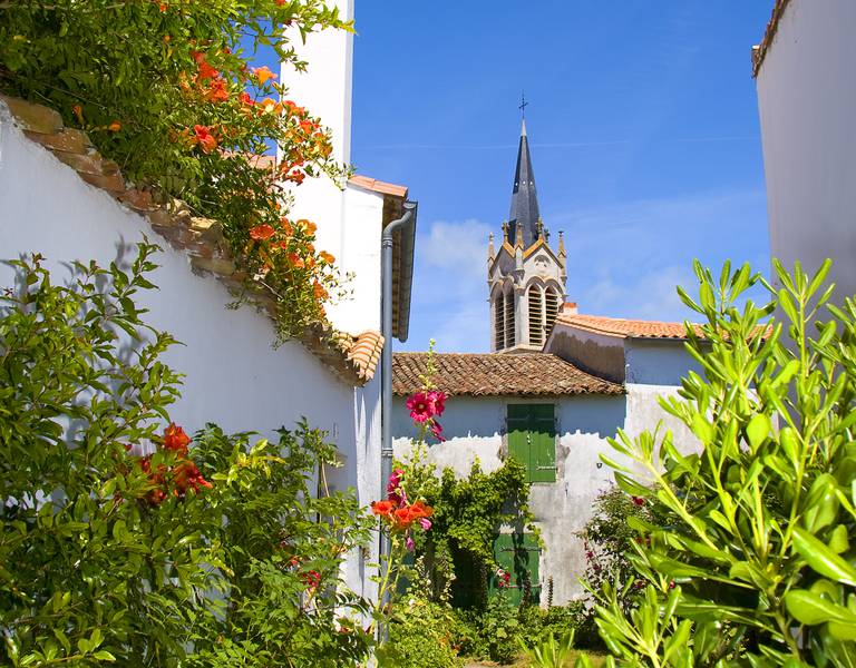Village aux façades blanches et clocher d'église.
